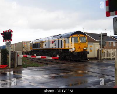 La locomotiva GBRF trasporta un treno merci intermodale attraverso la Queen Adelaide Level Crossing a Ely, Cambridgeshire, Regno Unito Foto Stock