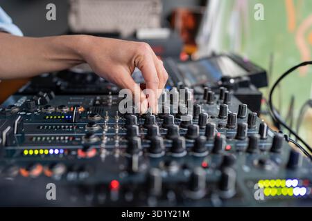 Donna radio DJ suona la musica in studio stazione radio su console di mixaggio, mano primo piano. Foto Stock