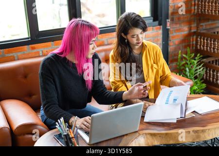 LGBTQ+ transgender uomo bello autentico Specialista con capelli rosa e trans non binari che lavorano insieme Design in cr Foto Stock