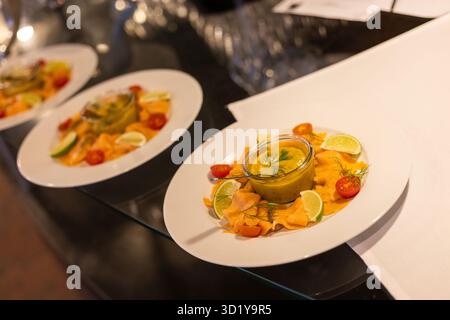 I piatti sono elegantemente disposti su un piano di appoggio nero, caratterizzato da vivaci piatti di pesce con ingredienti freschi come lime e pomodori. Gli ospiti possono usufruire dell'accesso wi-fi a internet Foto Stock