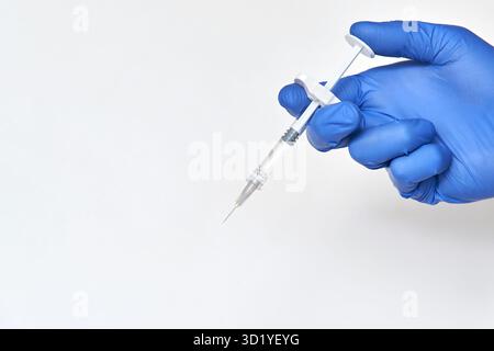 La persona nel guanto blu tiene in mano il flacone del vaccino con la siringa. Concetto di farmacia per iniezione. Terapia infermieristica medica. Le persone salute mani sci Foto Stock