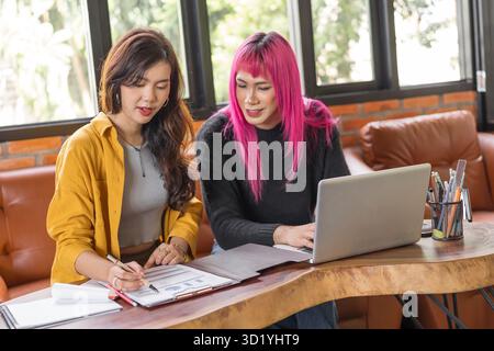 LGBTQ+ transgender uomo bello autentico Specialista con capelli rosa e trans non binari che lavorano insieme Design in cr Foto Stock