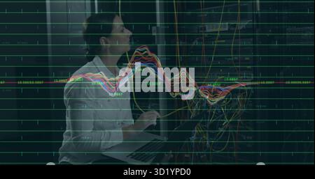 Tecnico IT che indossa una camicia bianca per regolare i cavi Ethernet nella sala server, con laptop e sovrapposizioni Foto Stock