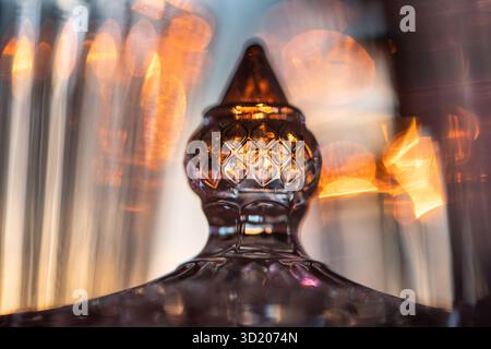 Piatto di caramelle in cristallo illuminato dalla luce del sole. Vaso sfaccettato con coperchio per riporre gioielli e caramelle Foto Stock