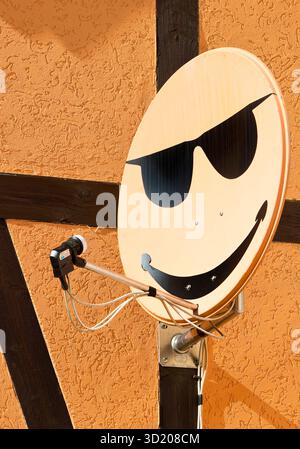 Parabola satellitare con sorriso su un muro di casa a Langenstein, Sassonia-Anhalt, Germania, Europa Foto Stock