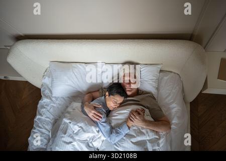 Amore e comprensione nel rapporto a lungo termine, coppia che dorme abbracciando nel letto, legame tranquillo Foto Stock