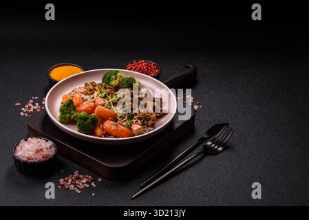 Ciotola con tofu, quinoa, broccoli e carote, microgreen Foto Stock