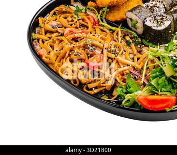 Delizioso piatto di ispirazione asiatica con spaghetti, sushi roll, pollo croccante e insalata fresca Foto Stock