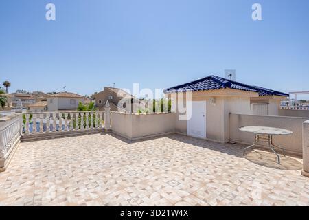 Grande terrazza sul tetto con ripostiglio, tavolo rotondo e vista panoramica delle case e del cielo Foto Stock