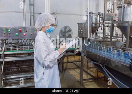 addetto all'igiene dell'industria delle conserve alimentari presso il nastro trasportatore, elenco di controllo della fabbrica di alimenti in scatola, team dell'ispettore dell'igiene Foto Stock