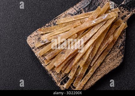 Cibo, spuntini o jerky a base di pesce salato disidratato secco con spezie. Spuntini di pesce Foto Stock