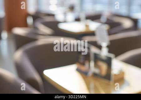 Interni vuoti e sfocati della caffetteria con luce soffusa e un'atmosfera accogliente al mattino Foto Stock