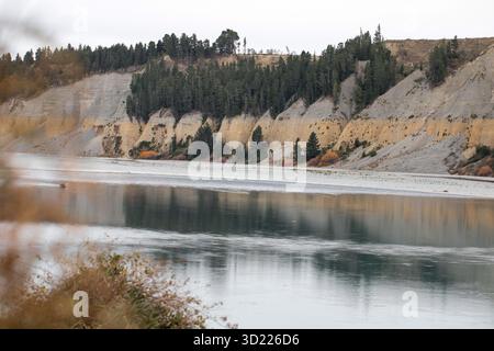 Il tranquillo fiume Rakaia scorre lungo ripide sponde con alberi di pino. Pittoresca gola famosa località turistica della nuova Zelanda. G Foto Stock