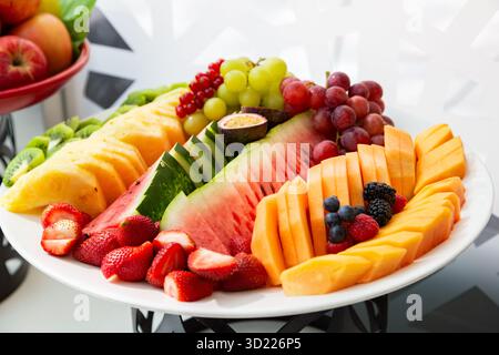 Assortimento di frutta appena tagliata su un piatto, con anguria e frutti di bosco vivaci Foto Stock