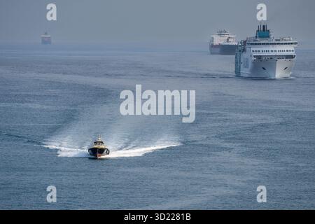 Pilota di porto che naviga di fronte alle navi che accedono al porto di Barcellona, ​​Catalonia, Spagna Foto Stock
