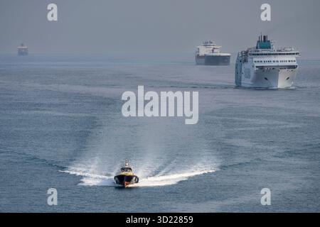 Pilota di porto che naviga di fronte alle navi che accedono al porto di Barcellona, ​​Catalonia, Spagna Foto Stock