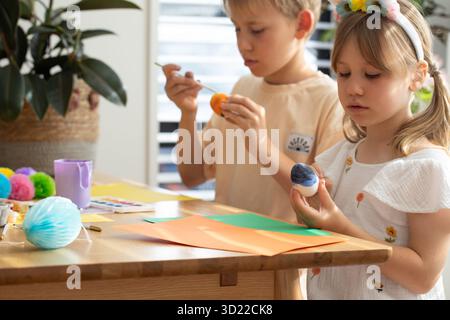 Fratello e sorella che dipingono uova di Pasqua. Concetto di buona Pasqua Foto Stock