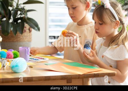 Fratello e sorella che dipingono uova di Pasqua. Concetto di buona Pasqua Foto Stock