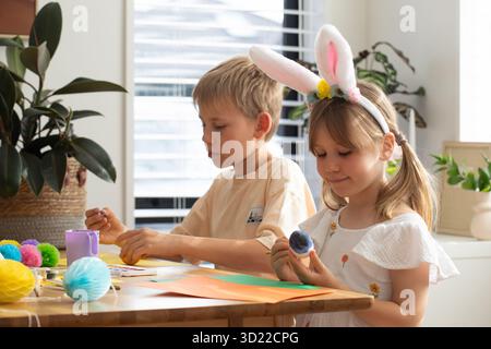 Fratello e sorella che dipingono uova di Pasqua. Concetto di buona Pasqua Foto Stock
