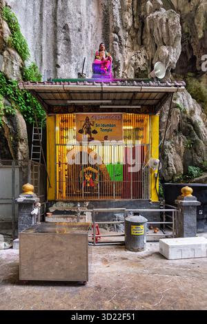Kuala Lumpur, Malesia - 18 febbraio 2025: Tempio di Sri Idumban, un vibrante santuario all'interno delle maestose grotte di Batu. Presenta una colorata statua della divinità e interni illuminati contro la roccia naturale. Foto Stock