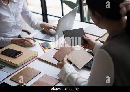 Designer di interni che presenta campioni di materiali in legno ecocompatibili per un arredamento sostenibile Foto Stock