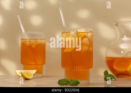 Tè freddo con limone e menta in un bicchiere e in una brocca. Drink estivi. Foto Stock