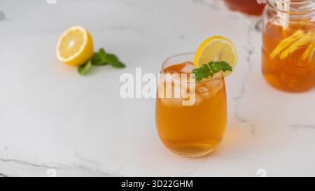 Un bicchiere con una bevanda rinfrescante estiva. Tè freddo con limone e menta. Foto Stock