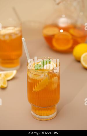 Tè freddo con limone e menta in un bicchiere e in una brocca. Drink estivi. Foto Stock