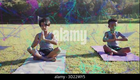 Meditare i ragazzi che praticano lo yoga di preghiera sui tappetini da yoga nel campo del parco, con sovrapposizione geometrica Foto Stock