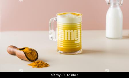 Latte curcuma su sfondo rosa. Latte di luna per un sonno migliore. Spazio di copia. Foto Stock