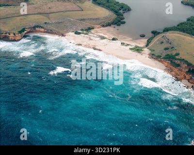 Vista aerea di una splendida costa con onde turchesi e vegetazione lussureggiante. Lombok, Sekaroh, Indonesia Foto Stock