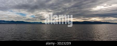 Spettacolare vista panoramica sulle acque scure del lago di Costanza (Bodensee) vicino a Lindau, Germania, con la sagoma delle Alpi svizzere o austriache bene Foto Stock