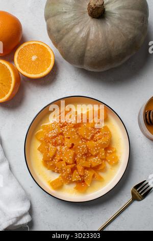 Dessert salutare con zucca tritata e arance nel recipiente Foto Stock