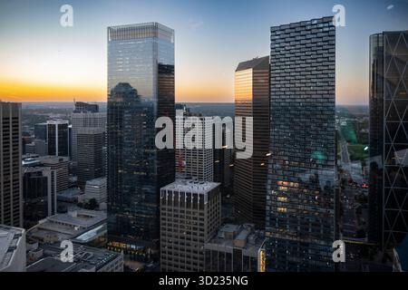 Skyline urbano al tramonto con alti grattacieli di vetro che riflettono la luce che svanisce. Calgary, Alberta, Canada Foto Stock