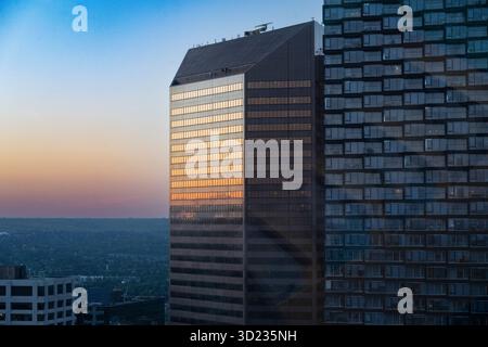 Alti e moderni edifici che riflettono un colorato cielo al tramonto in una vista urbana. Calgary, Alberta, Canada Foto Stock