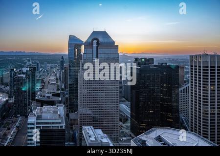 I grattacieli dominano il paesaggio cittadino durante un tramonto mozzafiato con un cielo azzurro. Calgary, Alberta, Canada Foto Stock