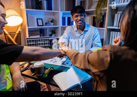 Ingegneri e architetti analizzano i modelli di costruzione e discutono le strategie di progetto, combinando conoscenze tecniche e idee creative per ottenere successo Foto Stock