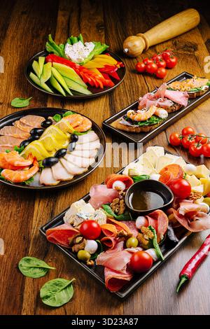 Varietà di antipasti colorati serviti su un tavolo di legno durante una riunione Foto Stock