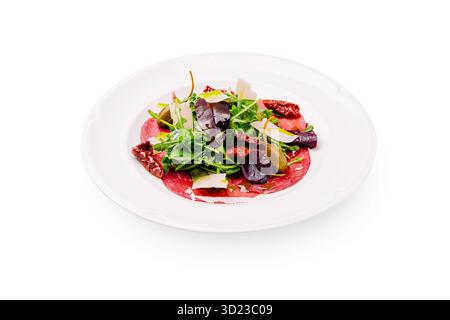 Insalata fresca con carpaccio di manzo e verdure miste servita su un piatto bianco Foto Stock