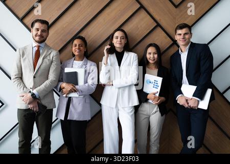 Ritratto del team aziendale creativo di successo che guarda la fotocamera e sorride. Diversi uomini d'affari in piedi insieme a startu Foto Stock