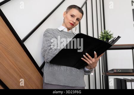 Capo donna di successo in ufficio con una cartella di documenti Foto Stock