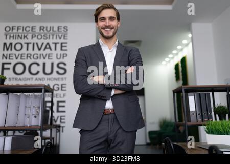 Ritratto di un avvocato maschio di successo in un edificio di uffici con le braccia incrociate Foto Stock