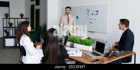 Riunione di brainstorming in un team di colleghi d'affari seduti al tavolo e che discutono del concetto di sviluppo aziendale Foto Stock