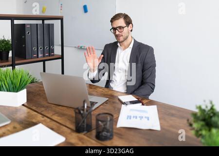 Elegante donna d'affari seduta su una sedia con un telefono in mano nel mezzo dell'ufficio Foto Stock