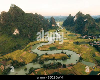 Vista aerea di lussureggianti montagne verdi, fiume tortuoso e risaie in una valle panoramica. Phong Nam, TR˘ng KH·nh District, Cao Bang, Vietnam Foto Stock