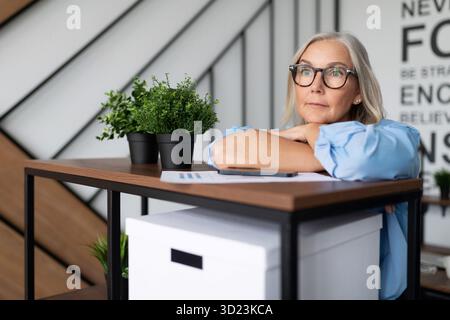 Ritratto di una donna d'affari anziana di mezza età in ufficio soddisfatta e premurosa, principi e regole di un cameriere di successo Foto Stock