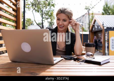 Giovane donna d'affari che lavora su un notebook all'aperto Foto Stock