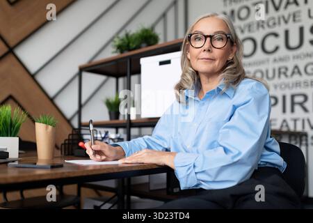 Caucasica donna d'affari anziana di mezza età sul posto di lavoro Foto Stock