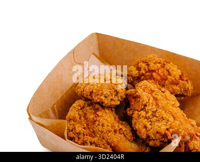 Pezzi di pollo fritti croccanti serviti in un vassoio di carta marrone Foto Stock