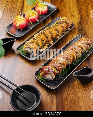 Sushi roll e antipasti serviti su piatti eleganti in un ambiente caldo Foto Stock